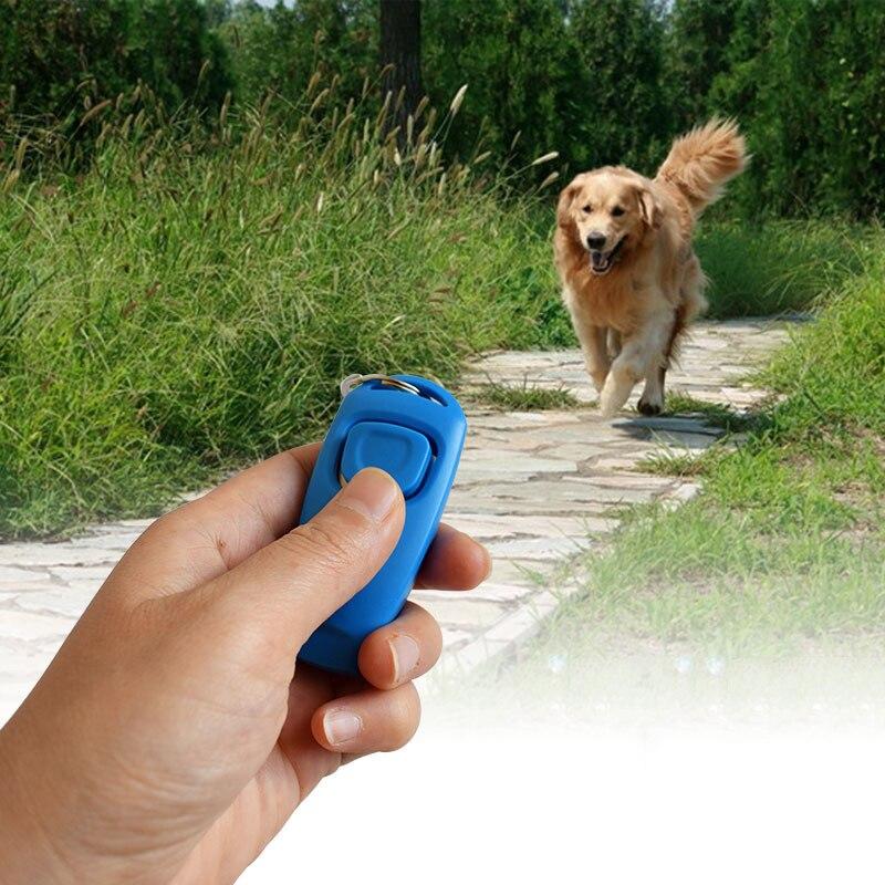 Hand holding a blue 2-in-1 pet training whistle with a running golden retriever in a grassy field.